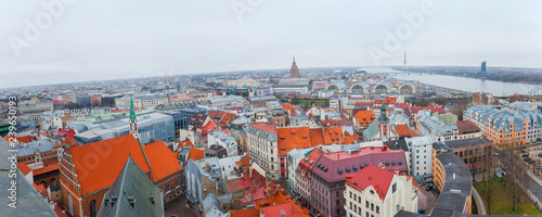 Aerial panoramic view of the Riga old town during winter day. Snowing in Riga. Top view of Dome Cathedral, statue of liberty, Daugava river and national library. Panorama