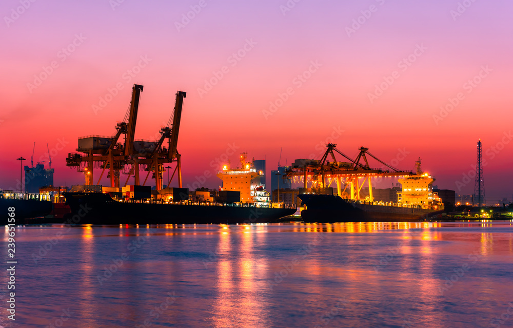Shipping port. Logistics and transportation of international import export container cargo ship loading or unloading by crane bridge in harbor at twilight dusk morning.