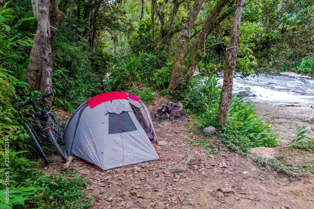 Gray camping tent with two bicycles next to a river in the middle of the forest, Presidente Nereu, Santa Catarina