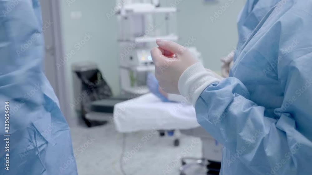 Nurse Helping to Surgeon to Put Protective Gloves on Before Operation. Nurse Helping to Surgeon to Put Protective Gloves on Before Operation.