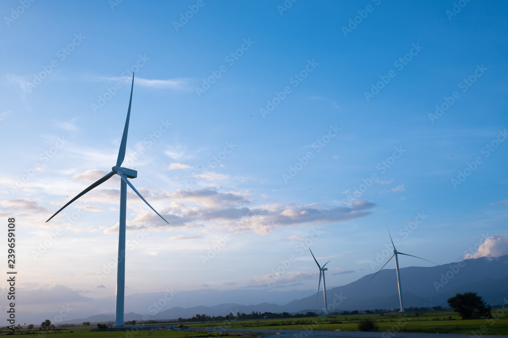 Wind turbine farm or windmill on blue sky. Turbine green energy electricity or wind turbine in a green field - Energy Production with clean and Renewable Energy. Phan Rang, Vietnam