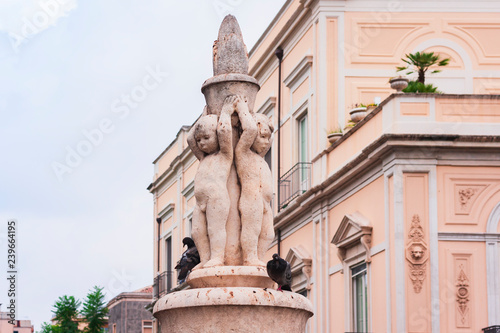 Ancient statue of boys made of stone in the famous city park Giardino Bellini in Catania, Sicily, Italy