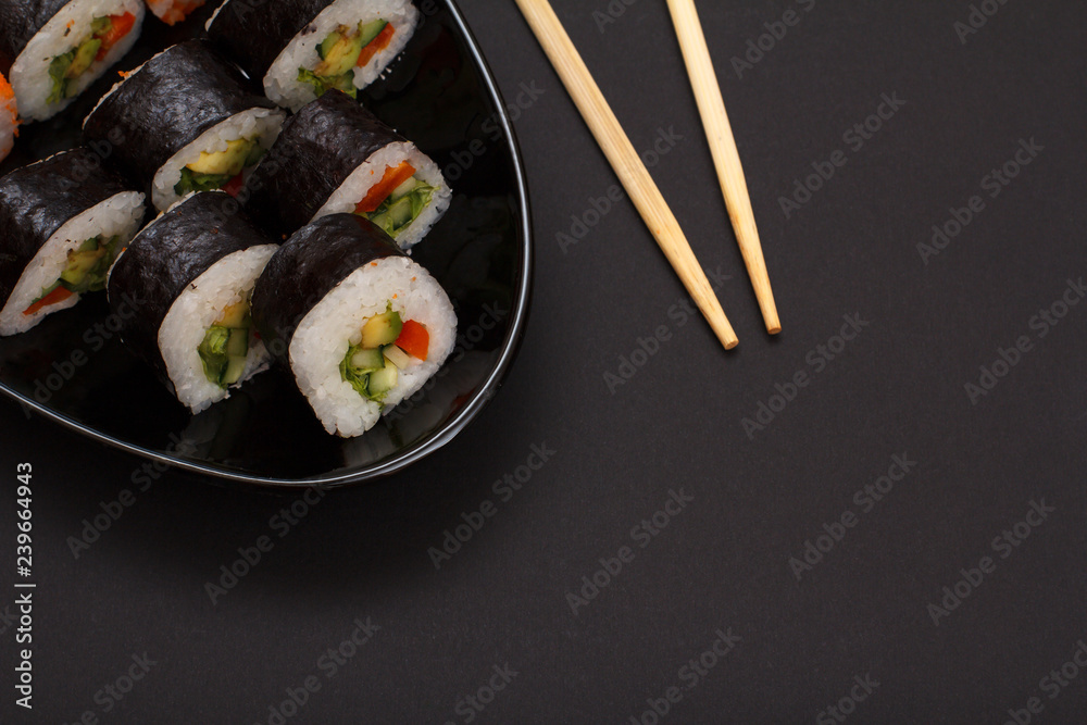 Sushi rolls in nori seaweed sheets and soy sauce on black background. Sushi rolls in nori seaweed sheets and soy sauce on black background.