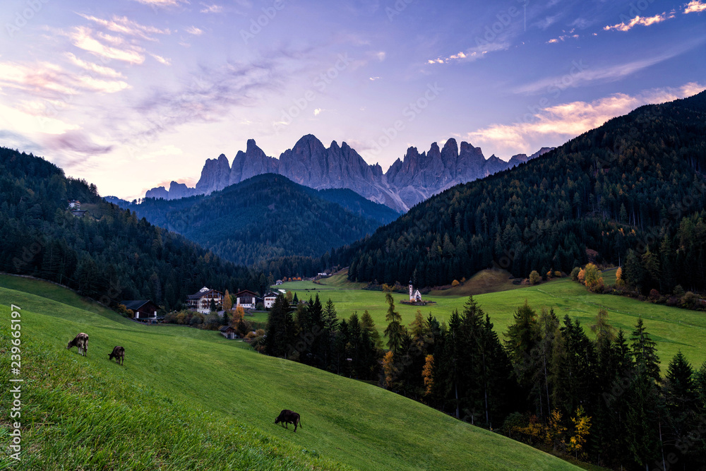 Early morning Landscape of Dolomite Alps. St Johann Church, Santa Maddalena, Val Di Funes, Dolomites, Italy. Fairy velley in Dolomites mountains. Amazing nature Background.