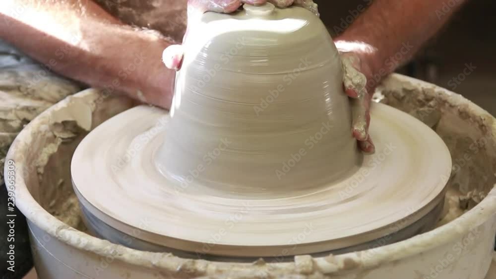 Artist potter in the workshop creating a ceramic vase. Hands closeup. Twisted potter's wheel. Small artistic craftsmen business concept. Artist potter in the workshop creating a ceramic vase. Hands closeup. Twisted potter's wheel. Small artistic craftsmen business concept.