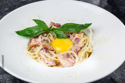 Pasta Carbonara. Spaghetti with bacon, parsel and parmesan cheese. Pasta Carbonara on white plate with parmesan. Italian food photo