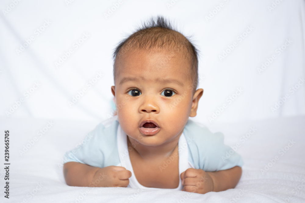 cute asian baby crawling on white carpet