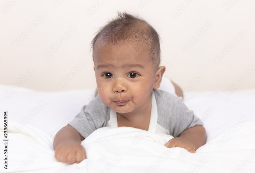 cute asian baby crawling on white carpet