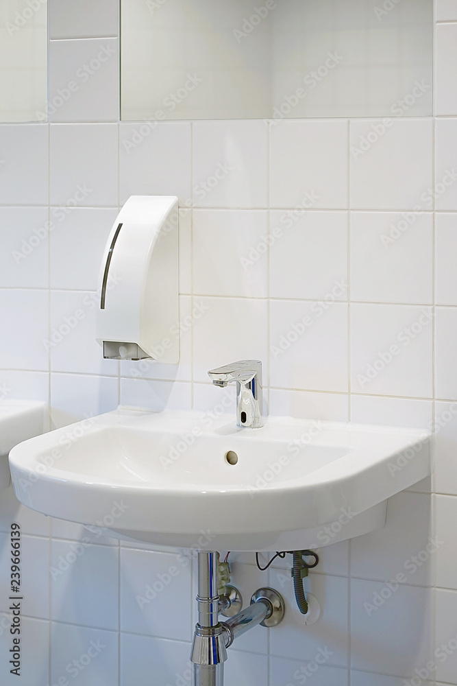 Fototapeta premium Public bathroom in the airport or restaurant, cafe. Bathroom interior sink with modern design. Interior of bathroom with washbasin and faucet. Close-up of bathroom. White bathroom.