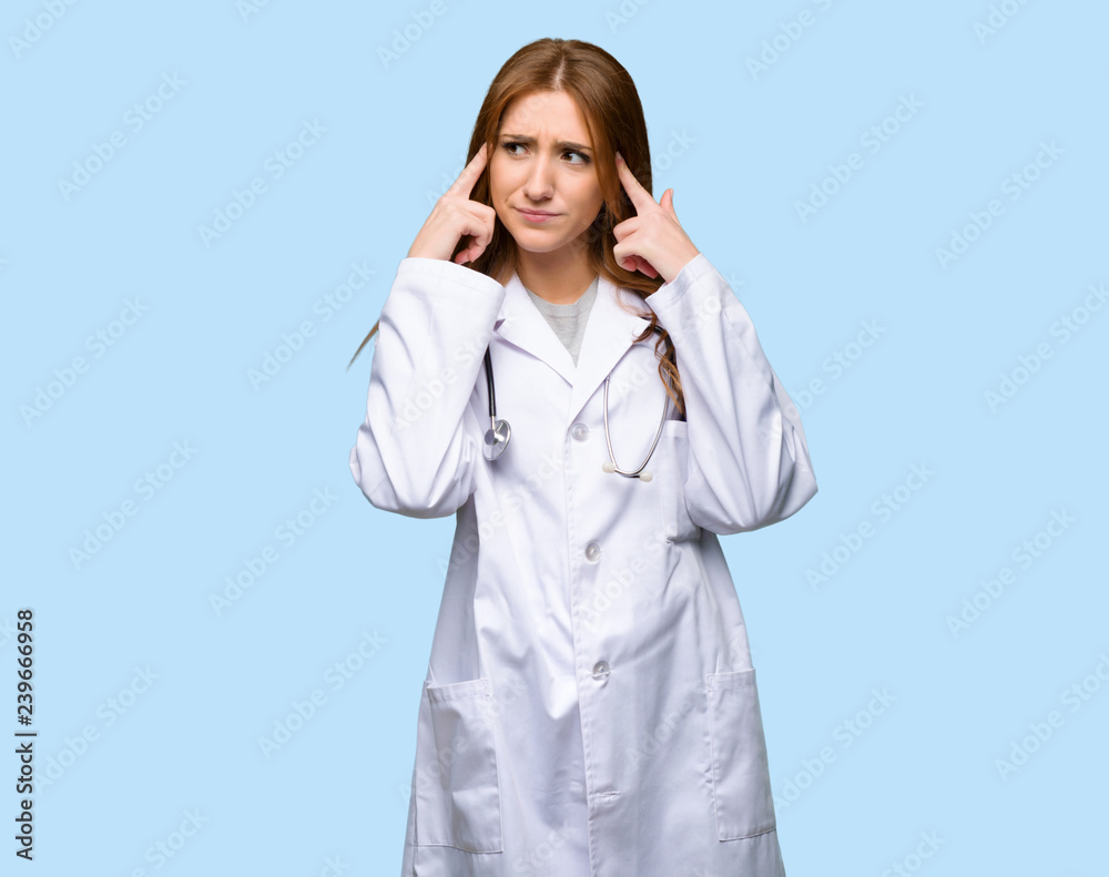 Redhead doctor woman having doubts and thinking on isolated blue background Redhead doctor woman having doubts and thinking on isolated blue background