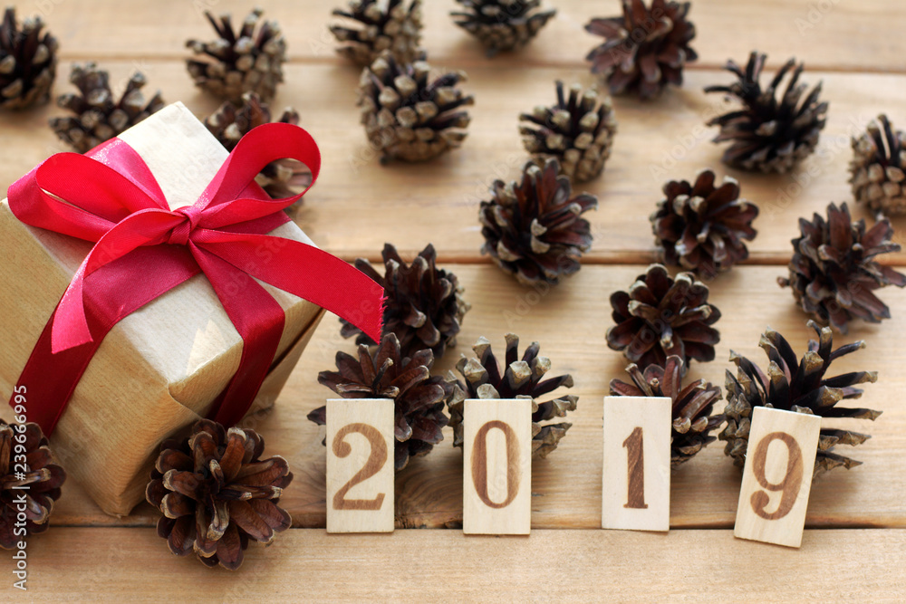 holiday gift and numbers 2019 on the background of fir cones on the table real new year holiday gift and numbers 2019 on the background of fir cones on the table real new year