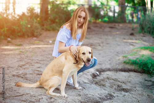 Girl playing with dog labrador outdoor