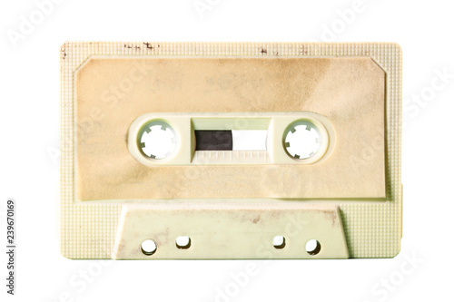 An old vintage cassette tape from the 1980s (obsolete music technology). Vivid colors: dirty cream plastic body, desert sand label. 