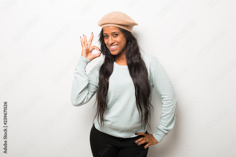 Young afro american woman on white wall showing an ok sign with fingers Young afro american woman on white wall showing an ok sign with fingers