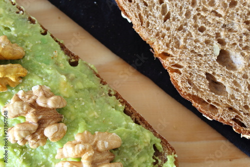 Healthy breakfast toast with avocado smash and nuts.