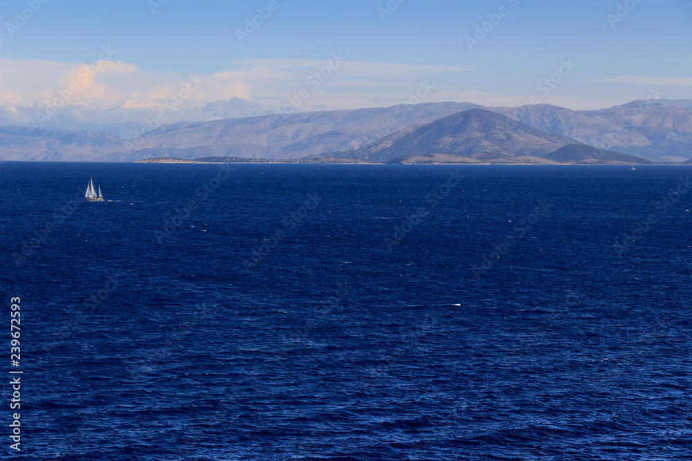 Sea horizon with sailboats in the wind: coast of Greece in the Aegean Sea. Beautiful Mediterranean coastline. Sea horizon with sailboats in the wind: coast of Greece in the Aegean Sea. Beautiful Mediterranean coastline.