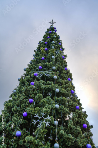 Christmas tree decorated with balls on the background of clouds