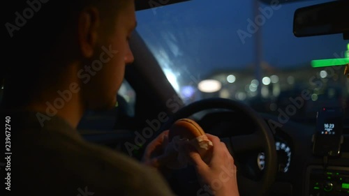 Wallpaper Mural A man eats a Cheeseburger from McDonalds sitting in a Car at Night Torontodigital.ca