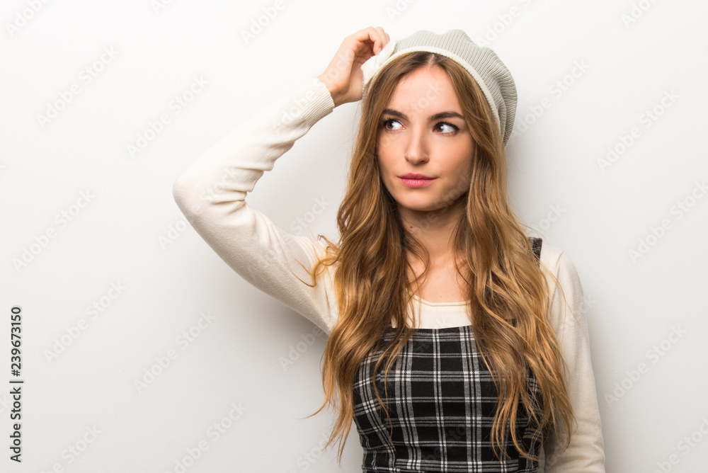 Fashionably woman wearing hat having doubts while scratching head Fashionably woman wearing hat having doubts while scratching head