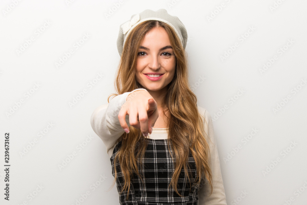 Fashionably woman wearing hat points finger at you with a confident expression Fashionably woman wearing hat points finger at you with a confident expression