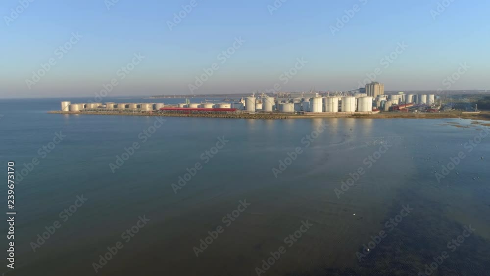 Large storage tanks of crude oil, gasoline, petrol, gas and other petrochemical goods in port terminal aerial view. Large storage tanks of crude oil, gasoline, petrol, gas and other petrochemical goods in port terminal aerial view.