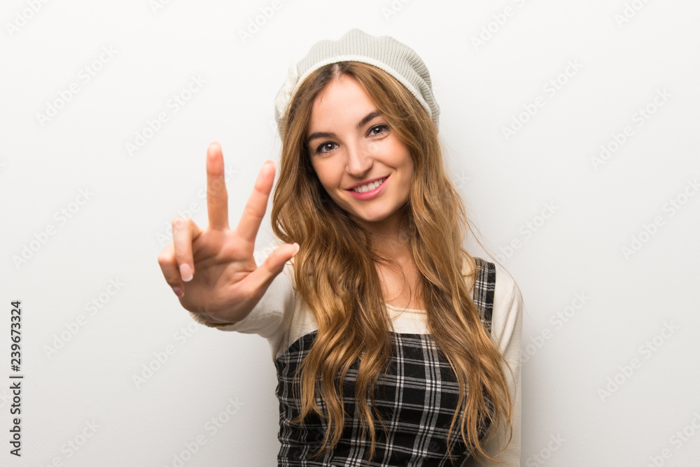 Fashionably woman wearing hat happy and counting three with fingers Fashionably woman wearing hat happy and counting three with fingers