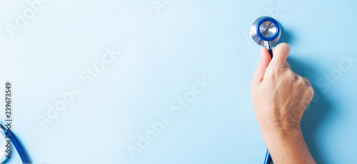 Healthcare concept - hand holding stethoscopee on blue background banner