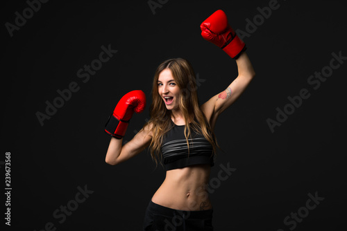 Sport woman with boxing gloves on dark background