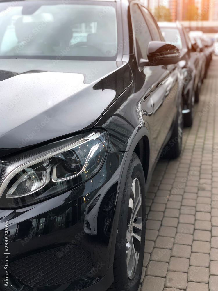 Focusing on the black car headlights on a street. Focusing on the black car headlights on a street.