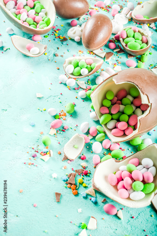 Colorful spring easter sweets background, with chocolate eggs, sugar sprinkles and marshmallow bunny, turquoise light blue concrete background copy space top view Colorful spring easter sweets background, with chocolate eggs, sugar sprinkles and marshmallow bunny, turquoise light blue concrete background copy space top view