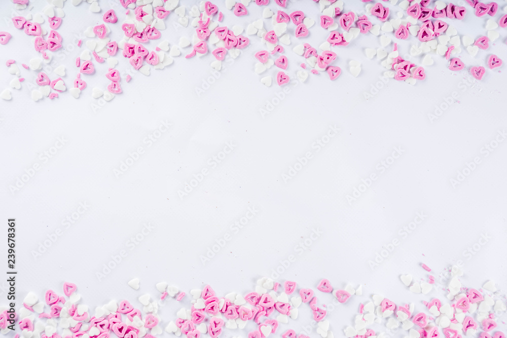 Valentine's sweets background, white background with sugar hearts sweet sprinkles, copy space top view, layout on white Valentine's sweets background, white background with sugar hearts sweet sprinkles, copy space top view, layout on white