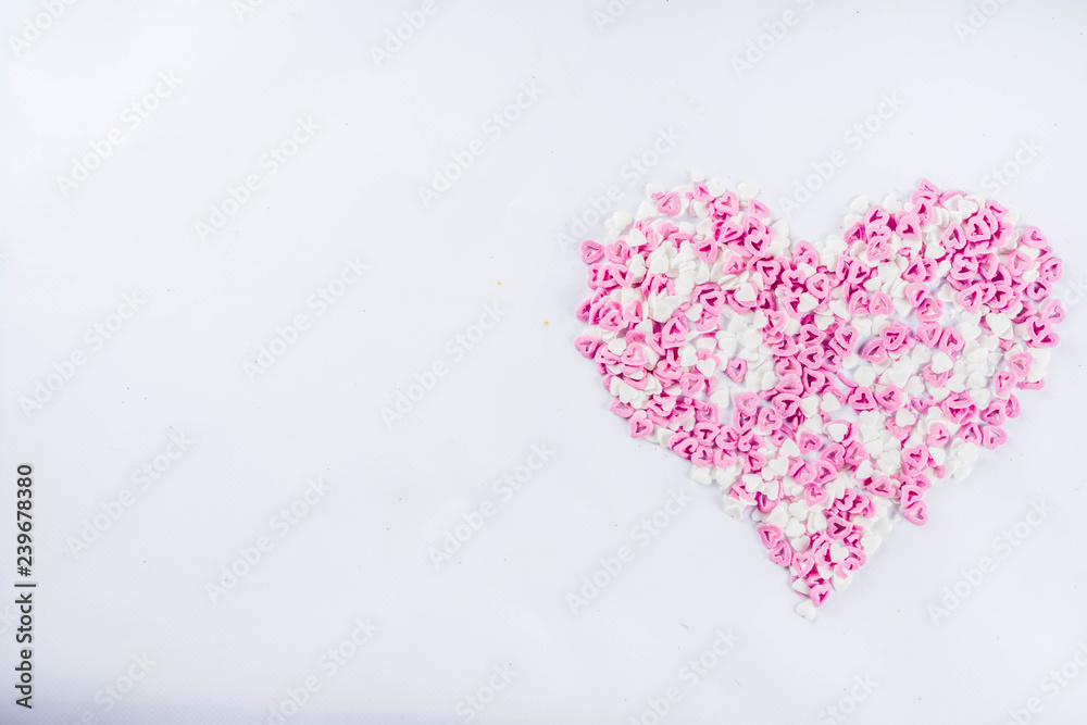 Valentine's sweets background, white background with sugar hearts sweet sprinkles, copy space top view, layout on white