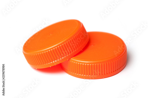 closeup of orange plastic plugs for recycling on white background
