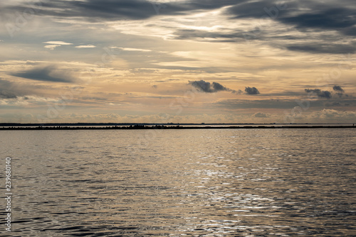 dramatic high contrast clouds in sunset over seaside beach