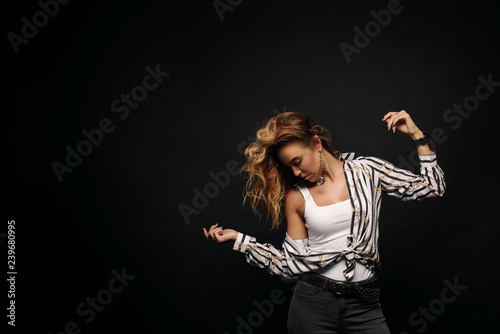 Portrait with copy space empty place of cheerful laughter funny comic girl having flying hair on black background, enjoying wind flow. Dancing for win on lottery 