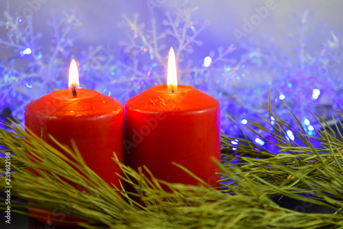 Red candles on the background of lights.Christmas card.