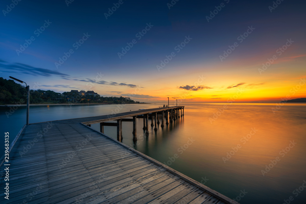Fototapeta premium Landscape of Wooded bridge in the port between sunrise