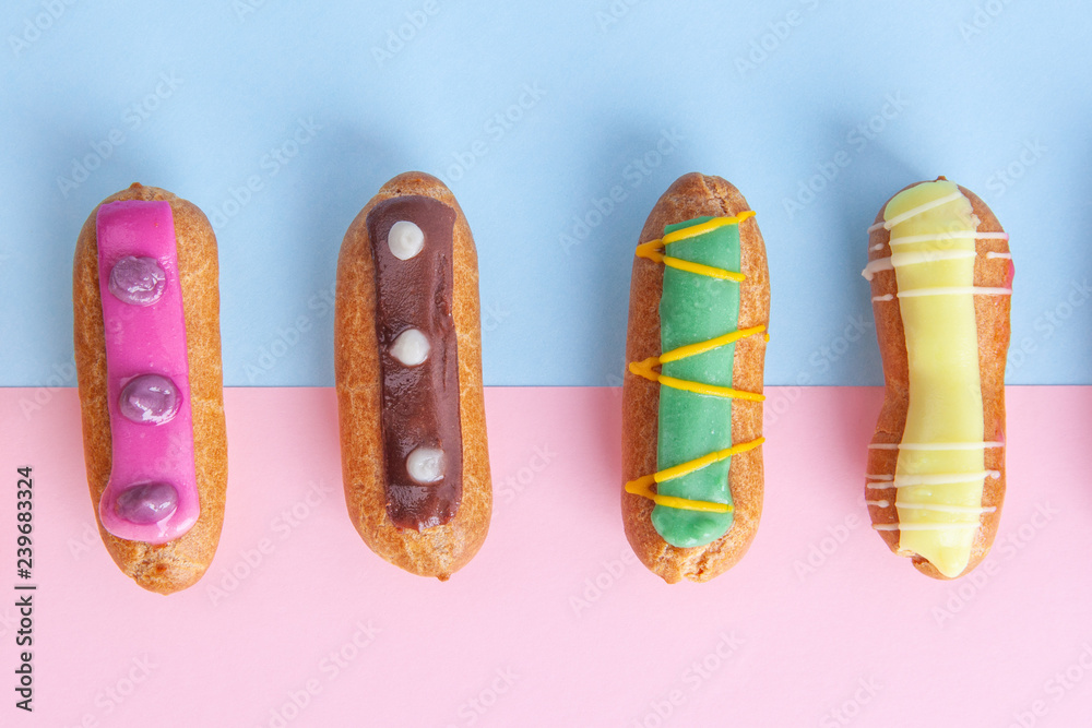 Closeup top view of eclairs on pink-blue background Closeup top view of eclairs on pink-blue background