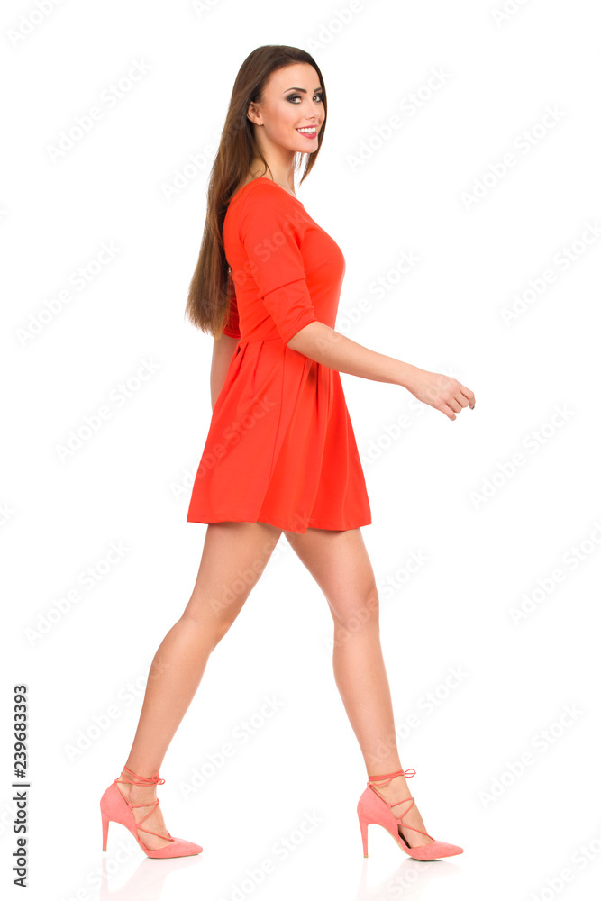 Beautiful Young Woman In Red Mini Dress And High Heels Is Walking And Smiling Beautiful Young Woman In Red Mini Dress And High Heels Is Walking And Smiling