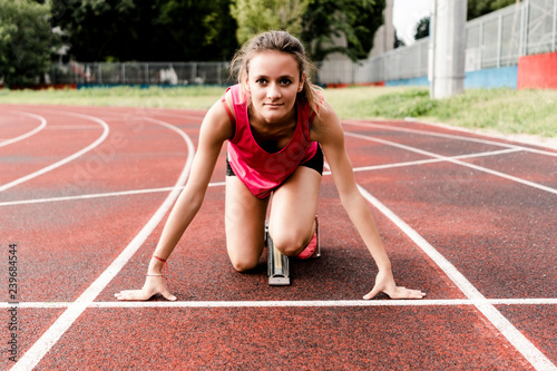 Teenage runner in starting position on race track