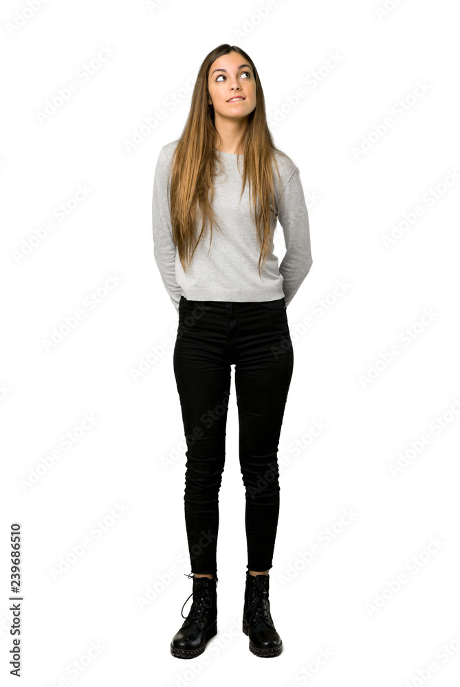 Full-length shot of young girl with confuse face expression while bites lip on isolated white background Full-length shot of young girl with confuse face expression while bites lip on isolated white background