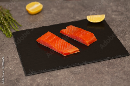 Raw fresh tasty salmon steaks placed on black slate. Wild atlantic fish