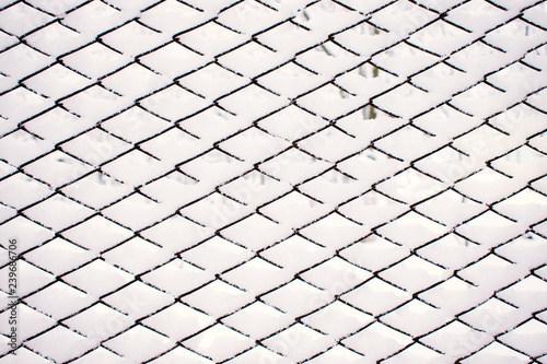 Abstract Snow winter pattern, background. Metal grid with white sticking snow