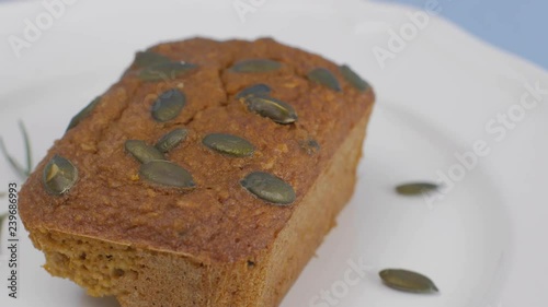 Gluten-Free pumpkin bread with pumpkin seed in white plate set on light blue background. photo