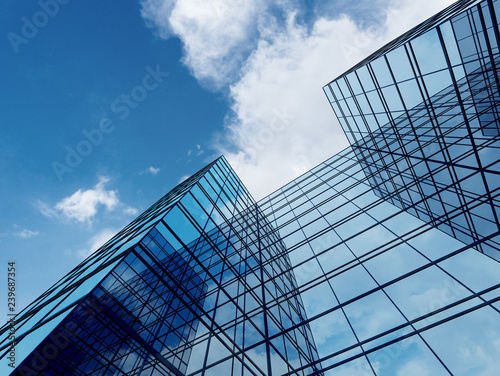 View of high rise glass building and dark steel window system on blue clear sky background,Business concept of future architecture,looking up to the sun light on the top of building. 3d render