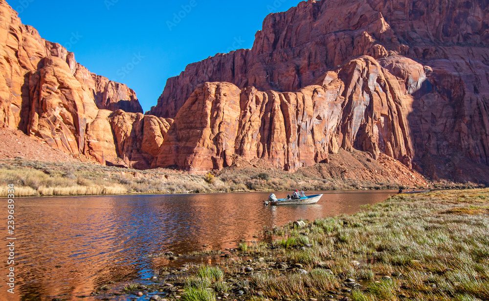 Man fly fishing from a boat on the Colorado river near Lees Ferry AZ