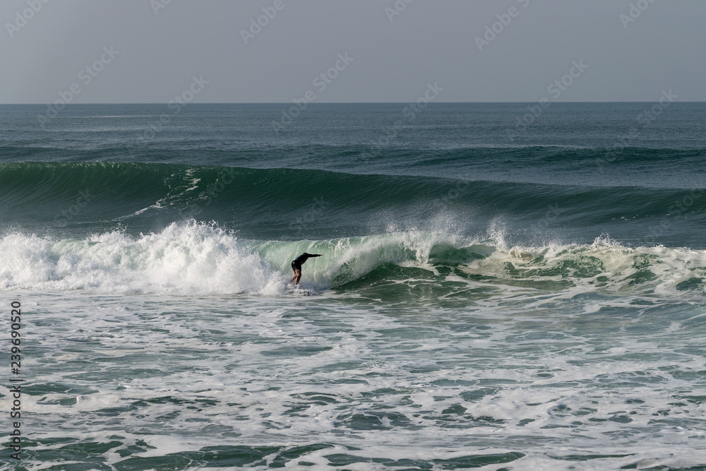 Atlantic wave and surfer, Nazare, Portugal.