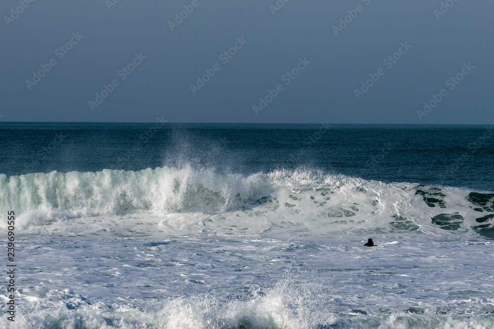Atlantic wave and surfer, Nazare, Portugal.