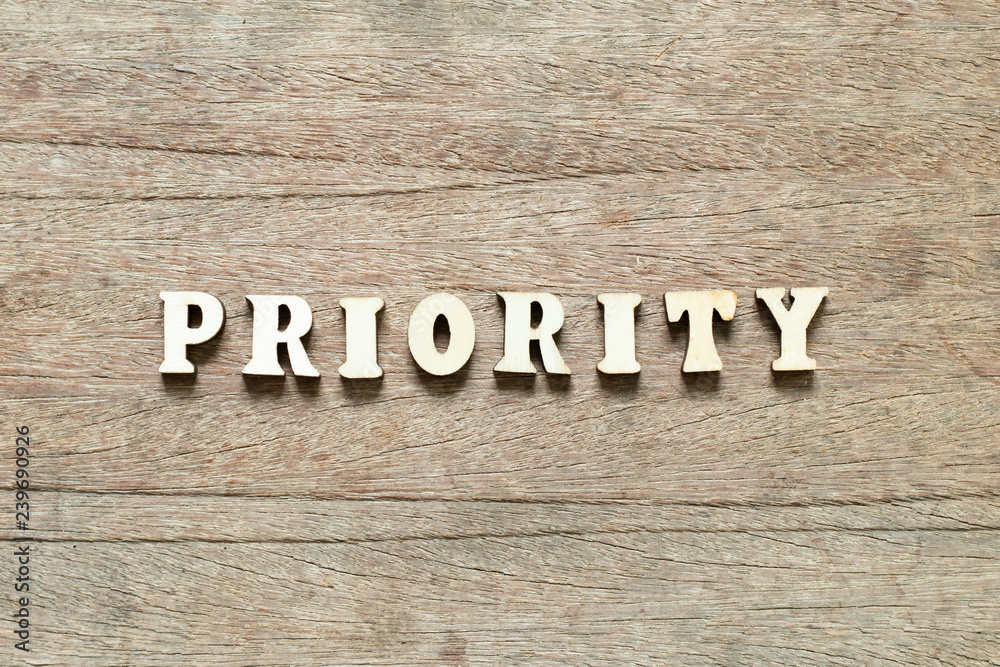 Letter block in word priority on wood background Letter block in word priority on wood background