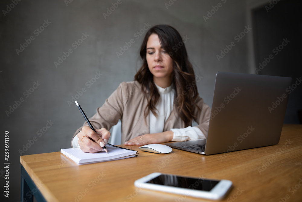 Young woman writing her ideas in a notebook Young woman writing her ideas in a notebook